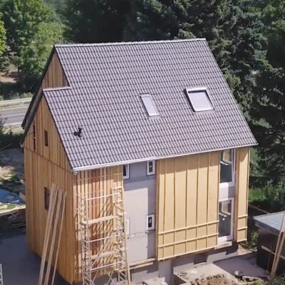 Drohnenbild einer mit Lärchenholz verschalten Strohdämmung (DD-Module hinter Holzweichfaserplatte) an einem Eigenheim